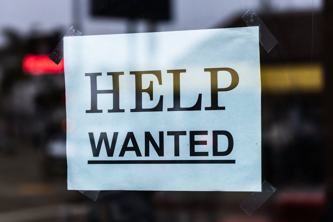 Mastering the First Impression: Your intriguing post title goes here Close-up of a Help Wanted sign taped to a glass window in a storefront.